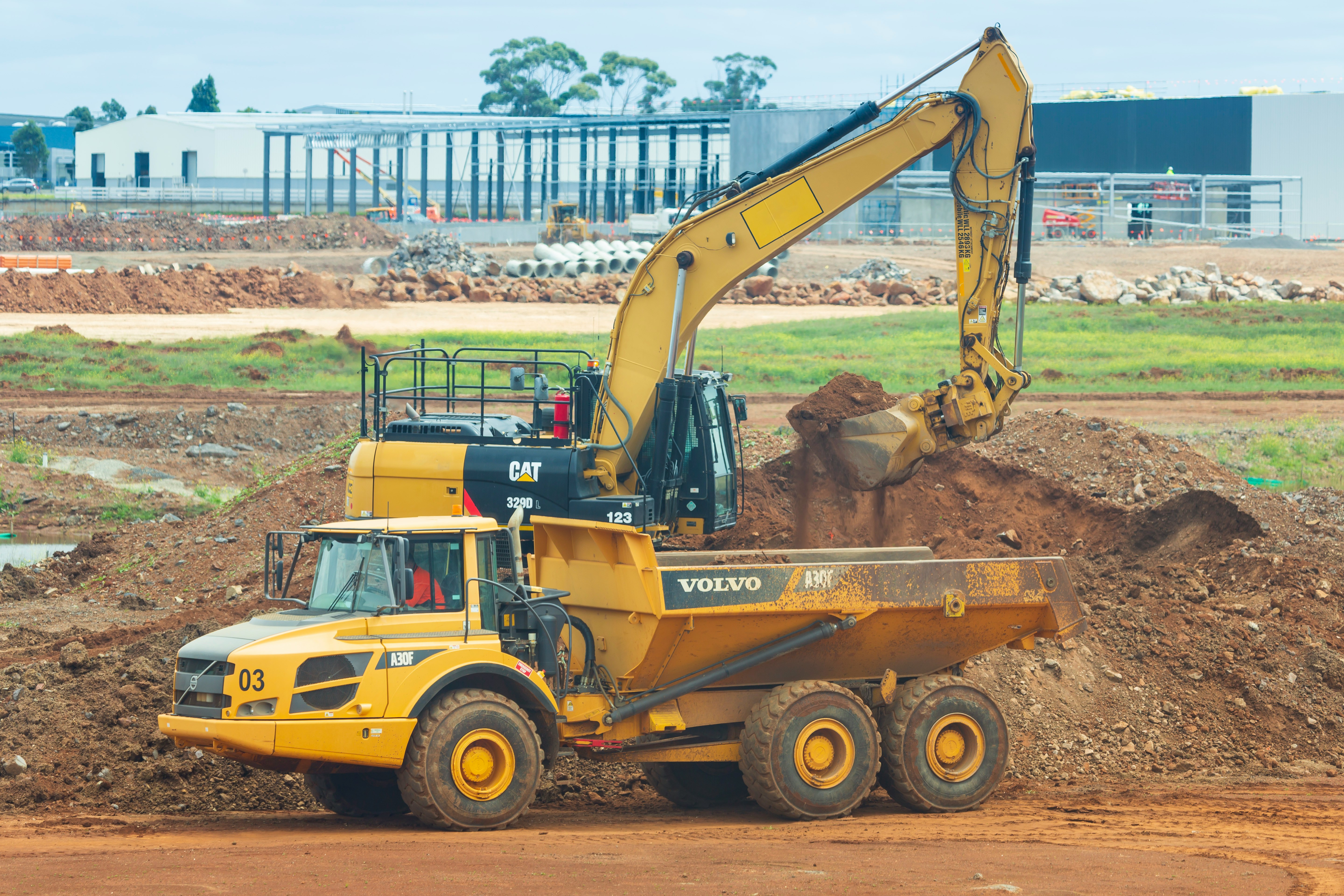Heavy vehicles at work at roads construction site.